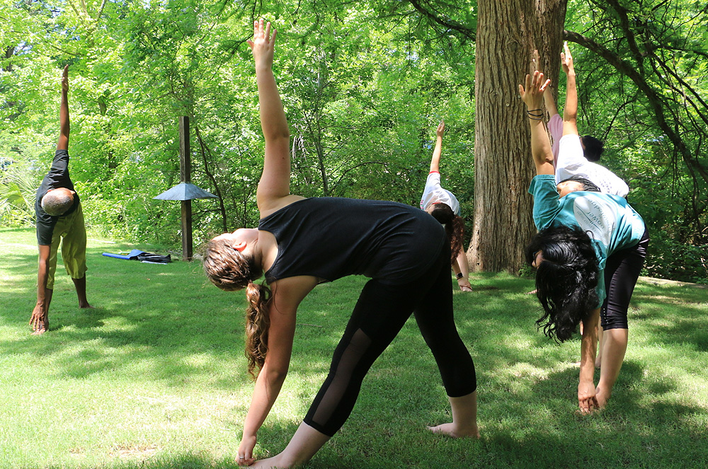 Instructor leading a group of students in practicing yoga