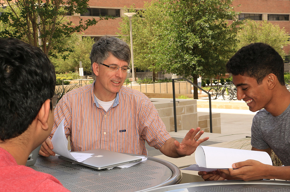 Professor meeting with students outside to carry on informal discussion