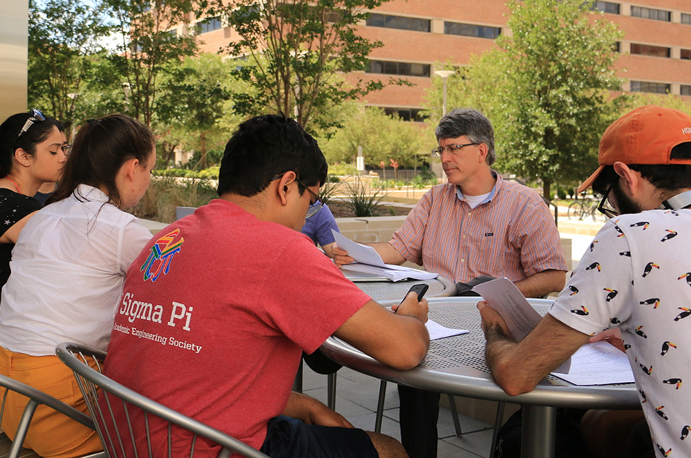 Professor and students meeting outdoors in informal discussion group
